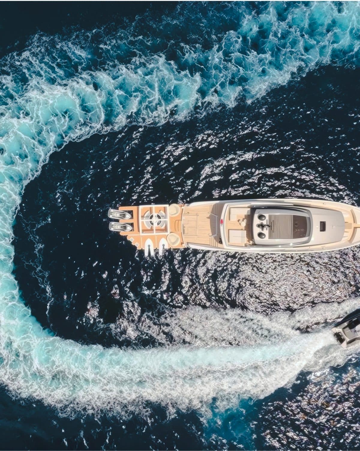 Vinci II au mouillage, vu du drone, l’annexe trace un cercle d’écume autour du yacht