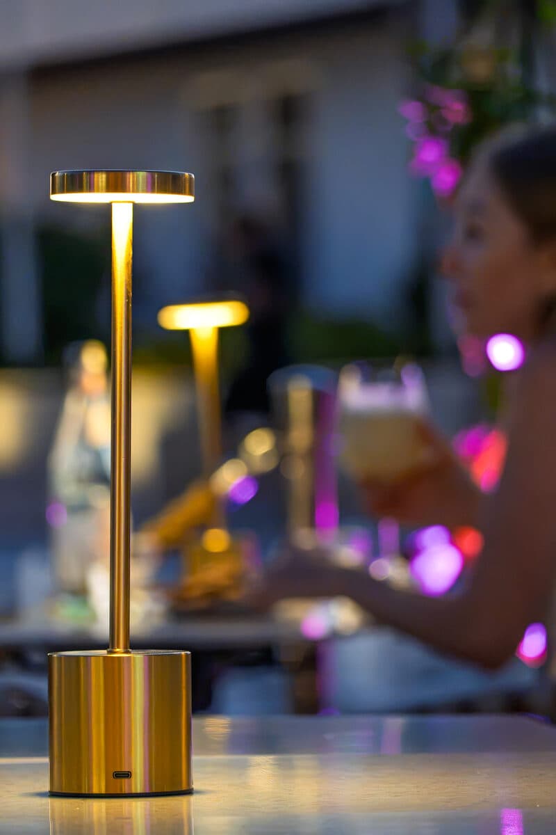 A golden lamp lit at nightfall, bougainvillea lit up in pink