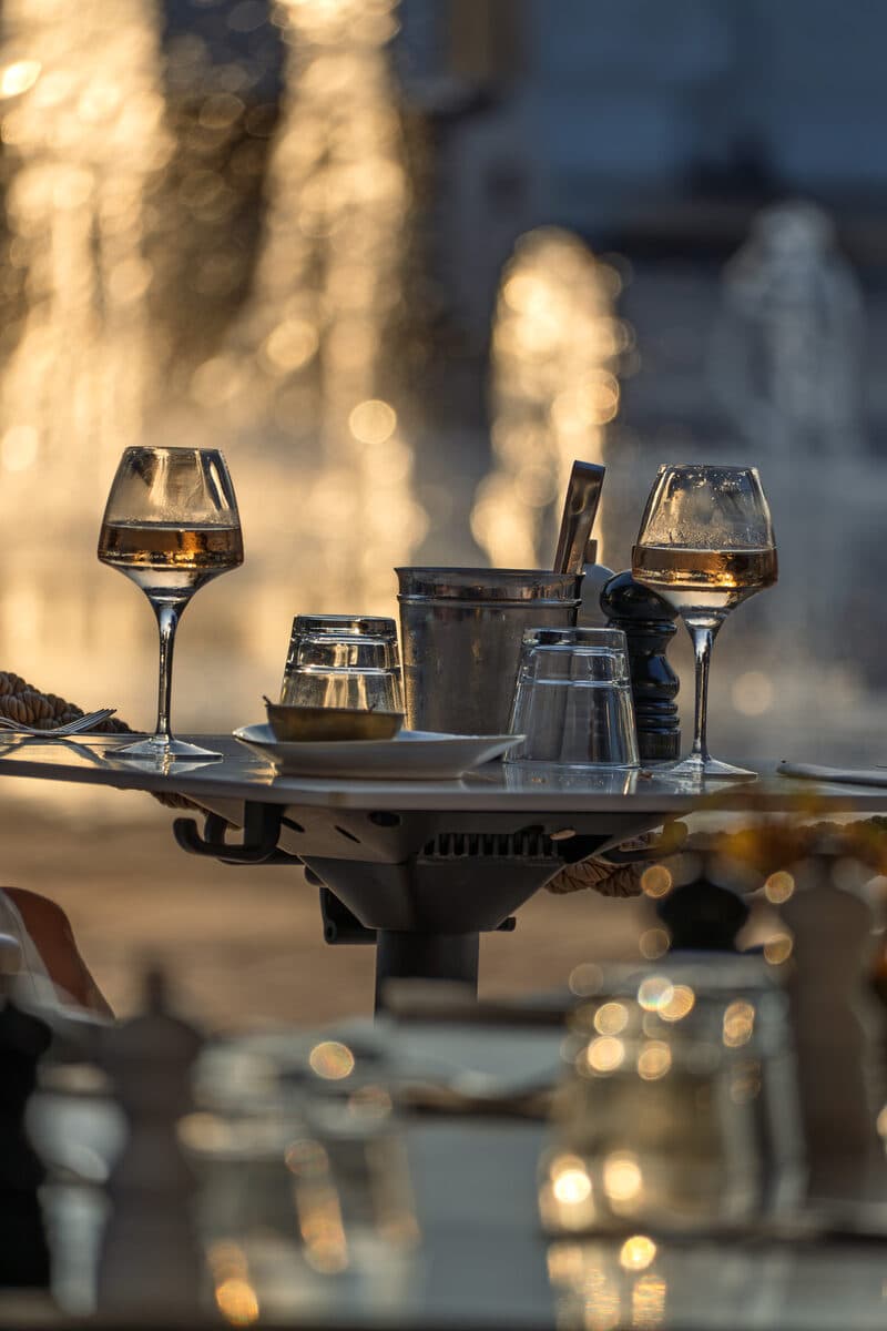 Two glasses of rosé and an ice bucket, backlit by the fountains