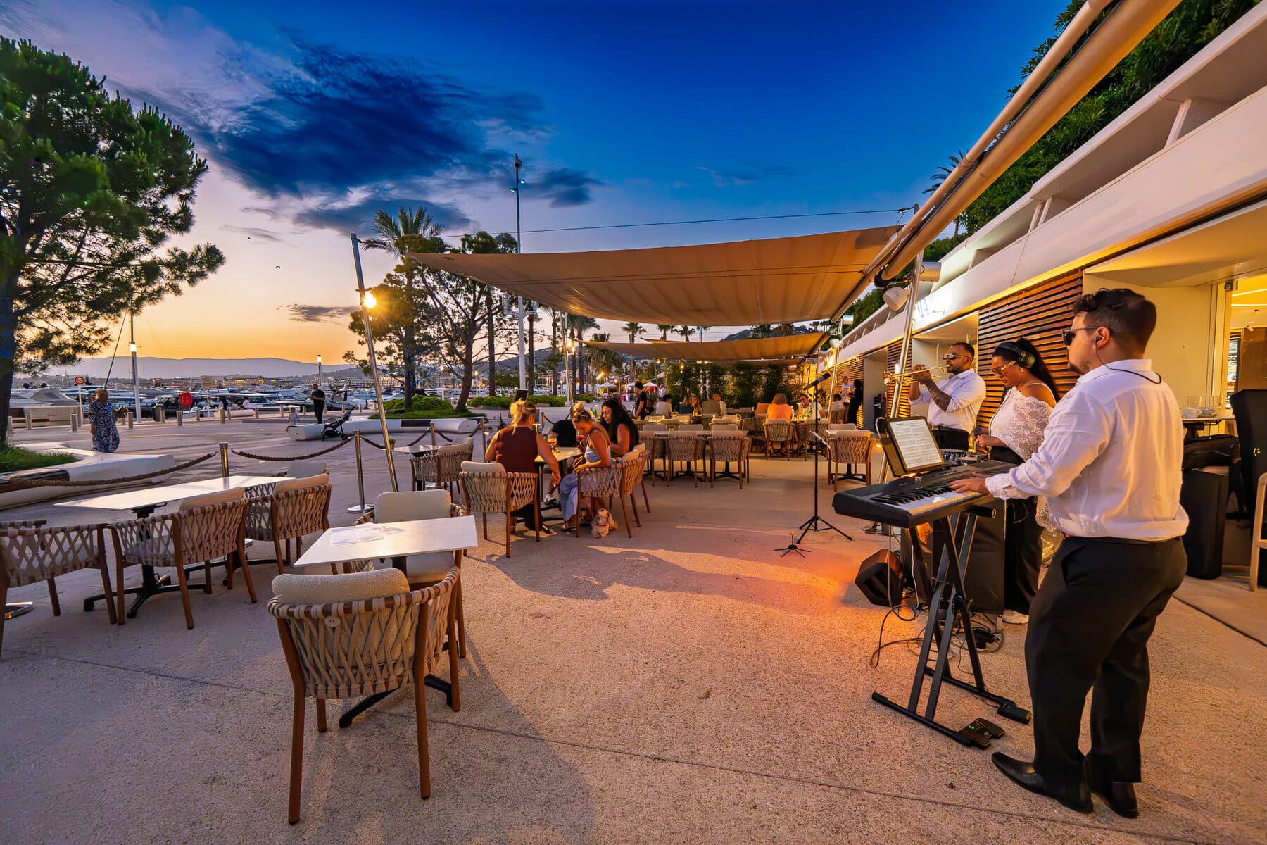 La terrasse du Loma au coucher du soleil, tables dressées face au port de Cannes