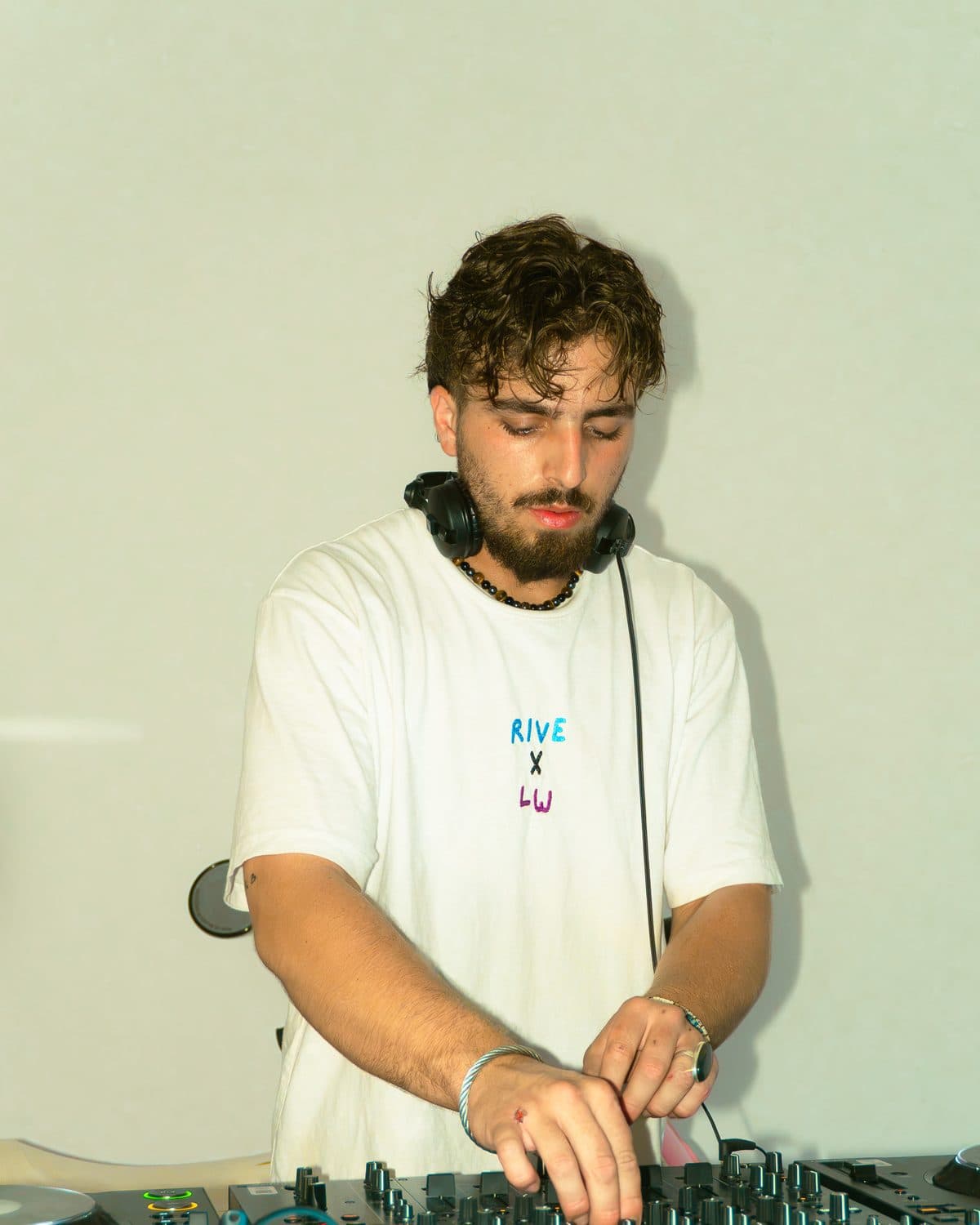 Logan What at the decks in a white T-shirt, light background