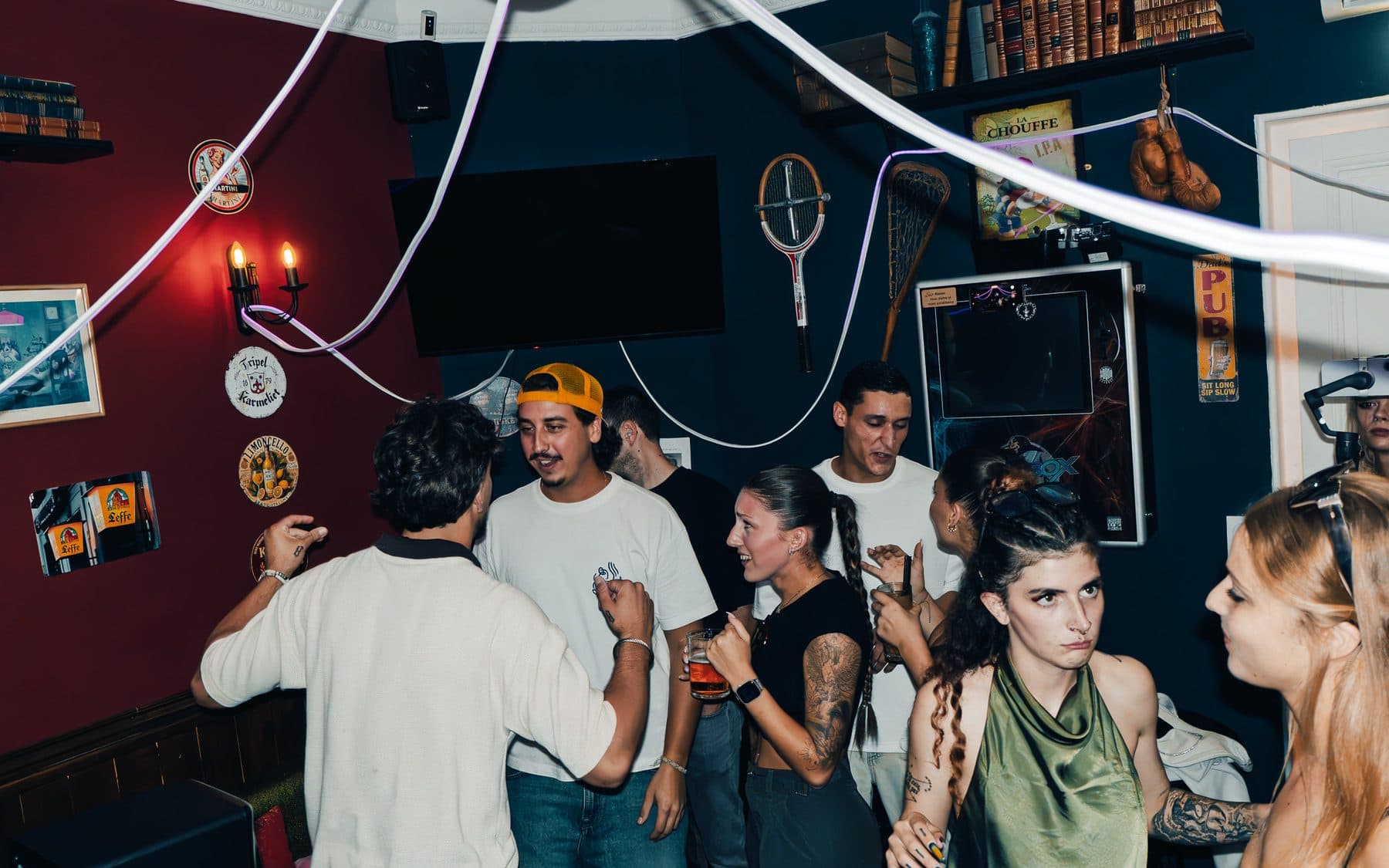 Guests dancing in a room with red curtains and white neon lights